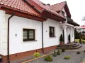 Elegancki cokół na elewacji domu, wykończony brązową, ziarnistą strukturą, chroni ściany przed wilgocią.