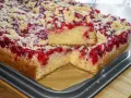Szybkie ciasto drożdżowe bez wyrabiania z malinami i kruszonką. Puszysty biszkopt, soczyste owoce i chrupiąca posypka.