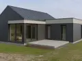 Nowoczesna dobudówka do starego domu, z dużymi przeszkleniami i grafitową elewacją. Projekty takich rozbudów to świetny sposób na odświeżenie wyglądu.