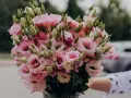Piękny eustoma bukiet w odcieniach różu i bieli, z licznymi pąkami, gotowy do wręczenia.