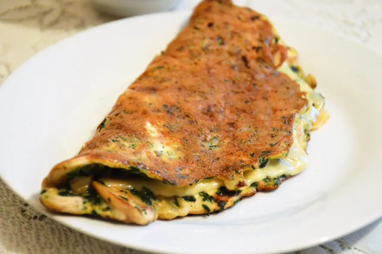 Złocisty omlet z ziołami i ciągnącym serem. Idealna lekka kolacja, która zaspokoi głód.