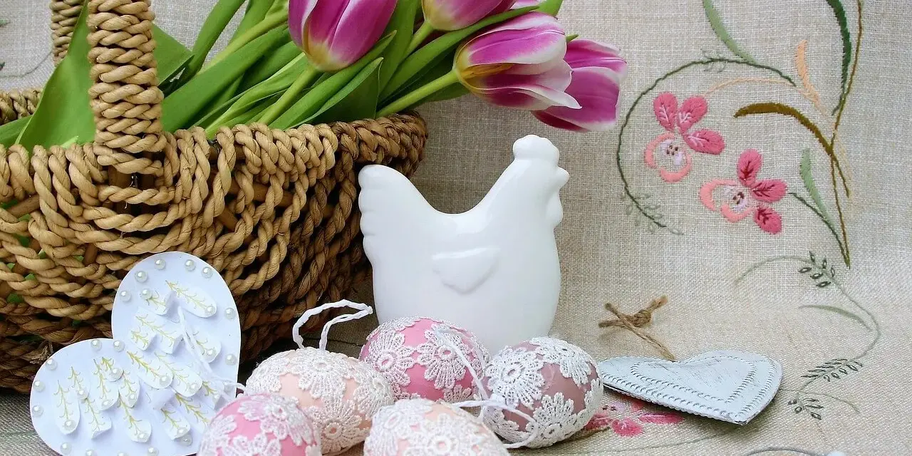 Wielkanocne dekoracje: koszyk z tulipanami, ceramiczna kurka, ozdobne jajka i serca.