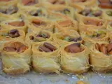 Słodkie gniazdka z cienkiego ciasta filo, wypełnione migdałami i pistacjami, błyszczą od syropu.