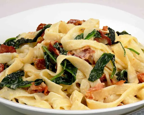 Pappardelle z chrupiącym boczkiem i szpinakiem w kremowym sosie mascarpone. Pyszne danie, które rozpływa się w ustach.