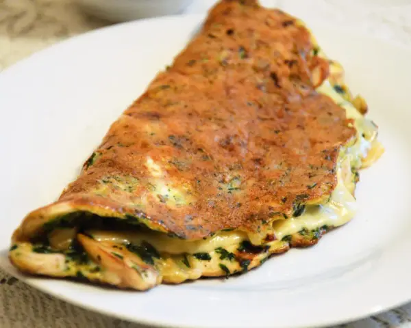 Złocisty omlet z ziołami i ciągnącym serem. Idealna lekka kolacja, która zaspokoi głód.