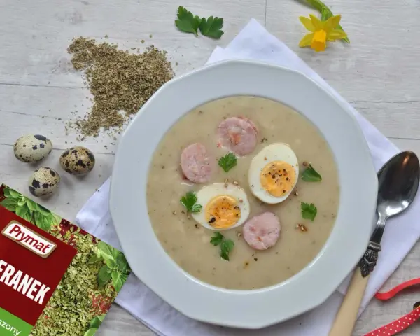 Aksamitny barszcz chrzanowy z jajkiem i kiełbaską, ozdobiony majerankiem. Idealny na Wielkanoc.