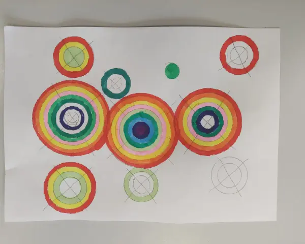 Kolorowa abstrakcja z koncentrycznymi okręgami przypominającymi tęczę.
