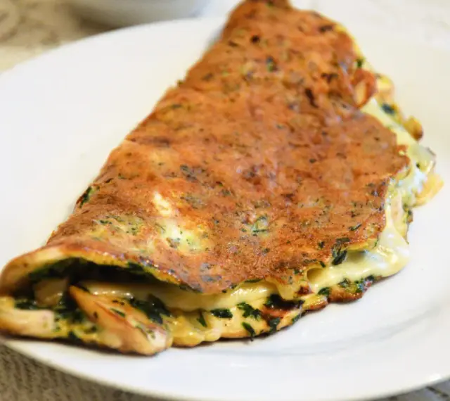 Złocisty omlet z ziołami i ciągnącym serem. Idealna lekka kolacja, która zaspokoi głód.
