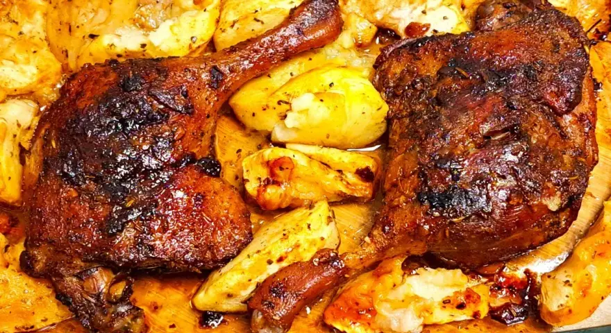Chrupiące udka z kaczki z piekarnika, otoczone pieczonymi ziemniakami, kuszą apetycznym wyglądem i aromatem.