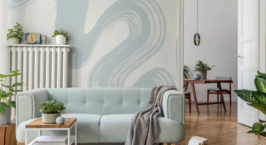 Miętowa kanapa i tapeta w stylu baby blue tworzą przytulną atmosferę.