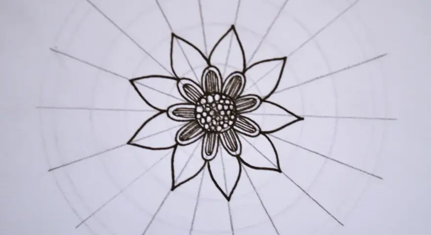 Kwiatowa mandala, rysowana czarnym tuszem, z delikatnymi okręgami i promieniami.