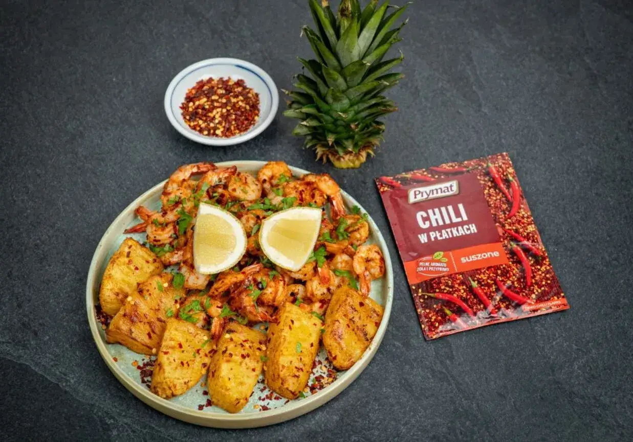 Krewetki z airfryer, podane z pieczonym ananasem i posypane płatkami chili. Idealne danie na szybki obiad.