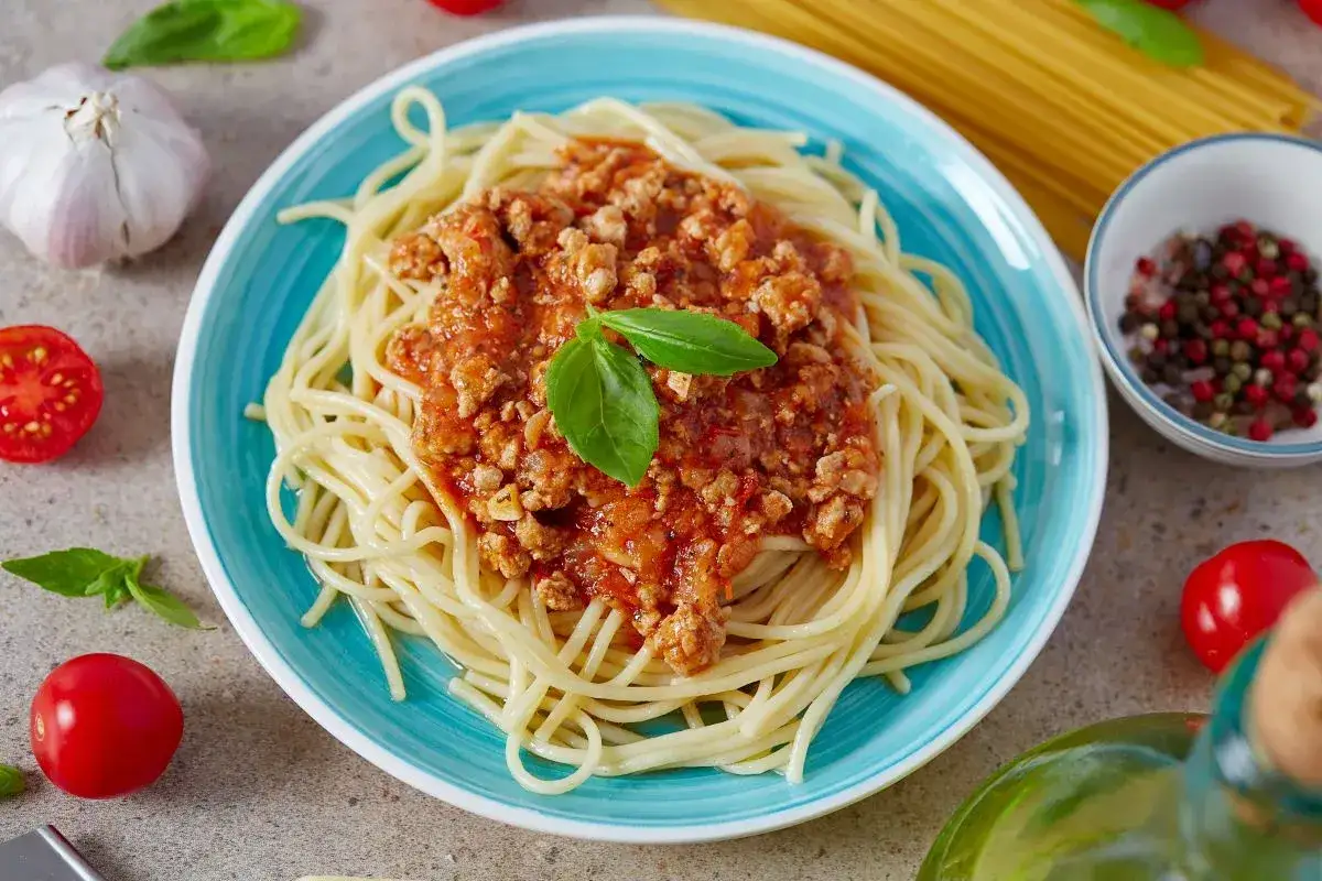 Pyszne spaghetti bolognese na talerzu, idealne na obiad. Dowiedz się, jak zrobić spaghetti krok po kroku!