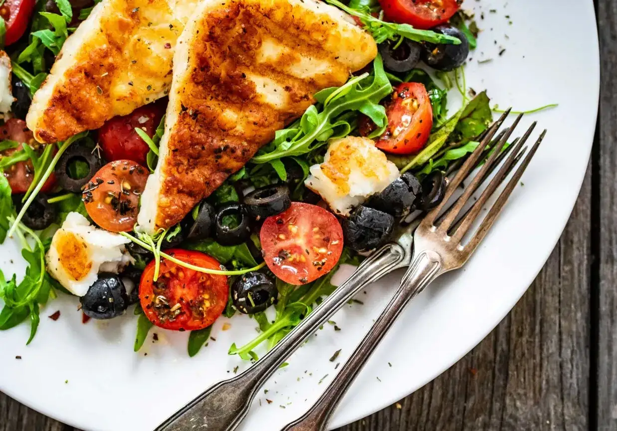 Rewelacyjna sałatka na grilla z grillowanym serem halloumi, pomidorkami koktajlowymi i czarnymi oliwkami. Idealna na letnie przyjęcie.