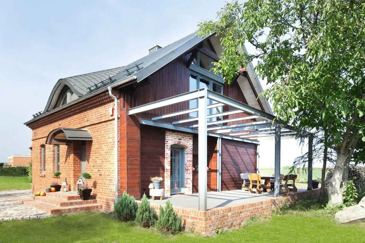 Nowoczesna dobudówka do starego domu z drewna i cegły, zadaszona pergola i taras. Projekty uwzględniające harmonię.